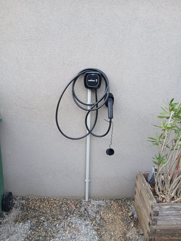 Borne de recharge pour voiture électrique installée contre la façade d’une villa à Vessy