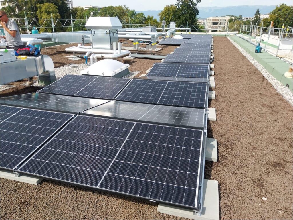 Panneaux photovoltaïques installés sur la toiture végétalisée d’un immeuble neuf à Genève